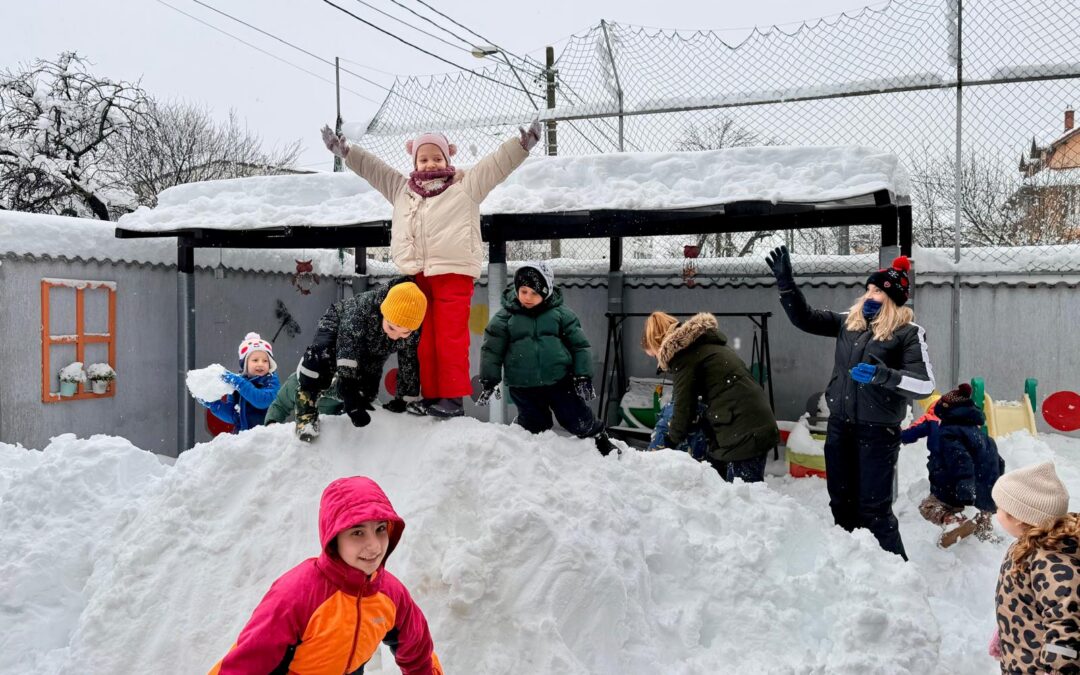 Toți copiii de la Grădinițele „Arc-en-Ciel” sunt fericiți că a nins din nou – și pentru că se pot bucura de troienele de zăpadă!